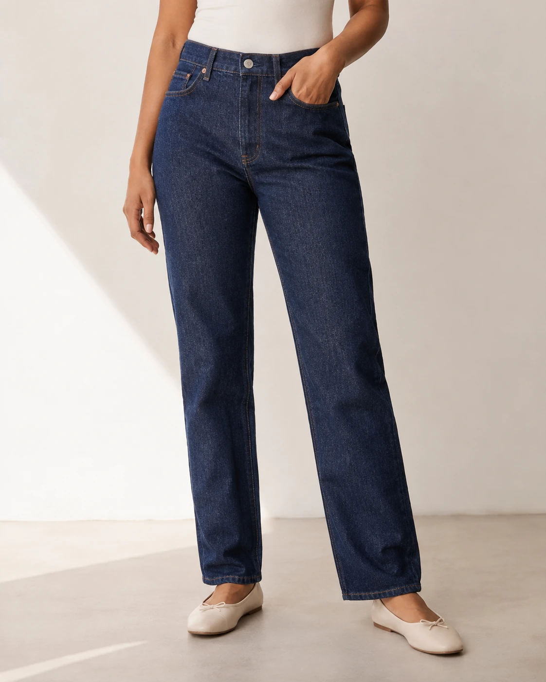 AI-generated product-focused view of straight-leg indigo jeans worn with an ivory top and flats