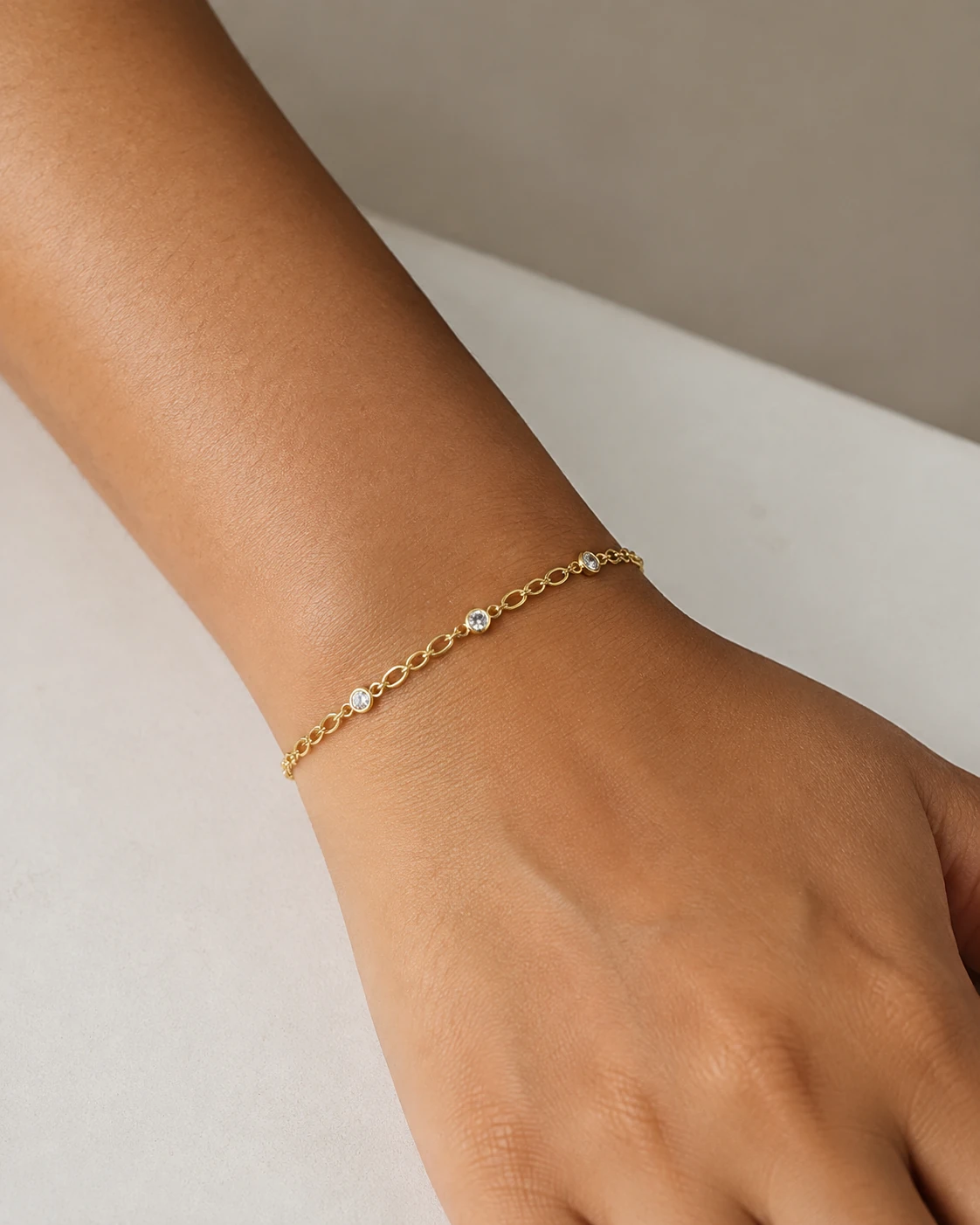 AI-generated close-up of a delicate gold link bracelet with clear stones on a wrist